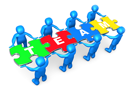 Team Of 8 Blue People Holding Up Connected Pieces To A Colorful